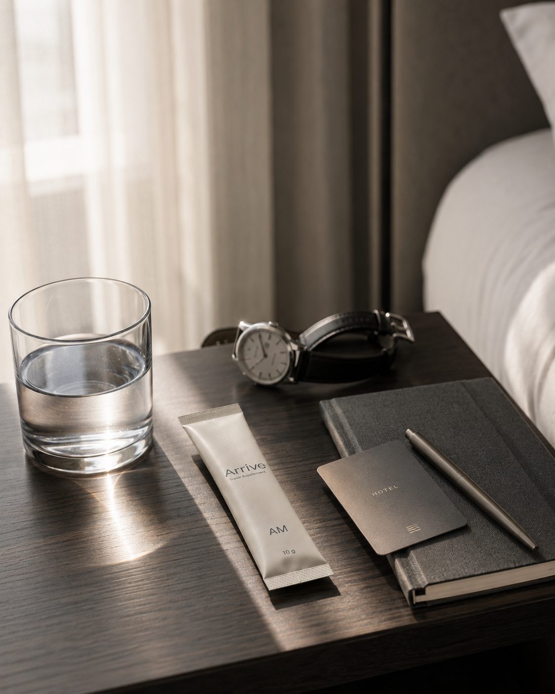 An Arrive AM stick on a hotel nightstand in morning light